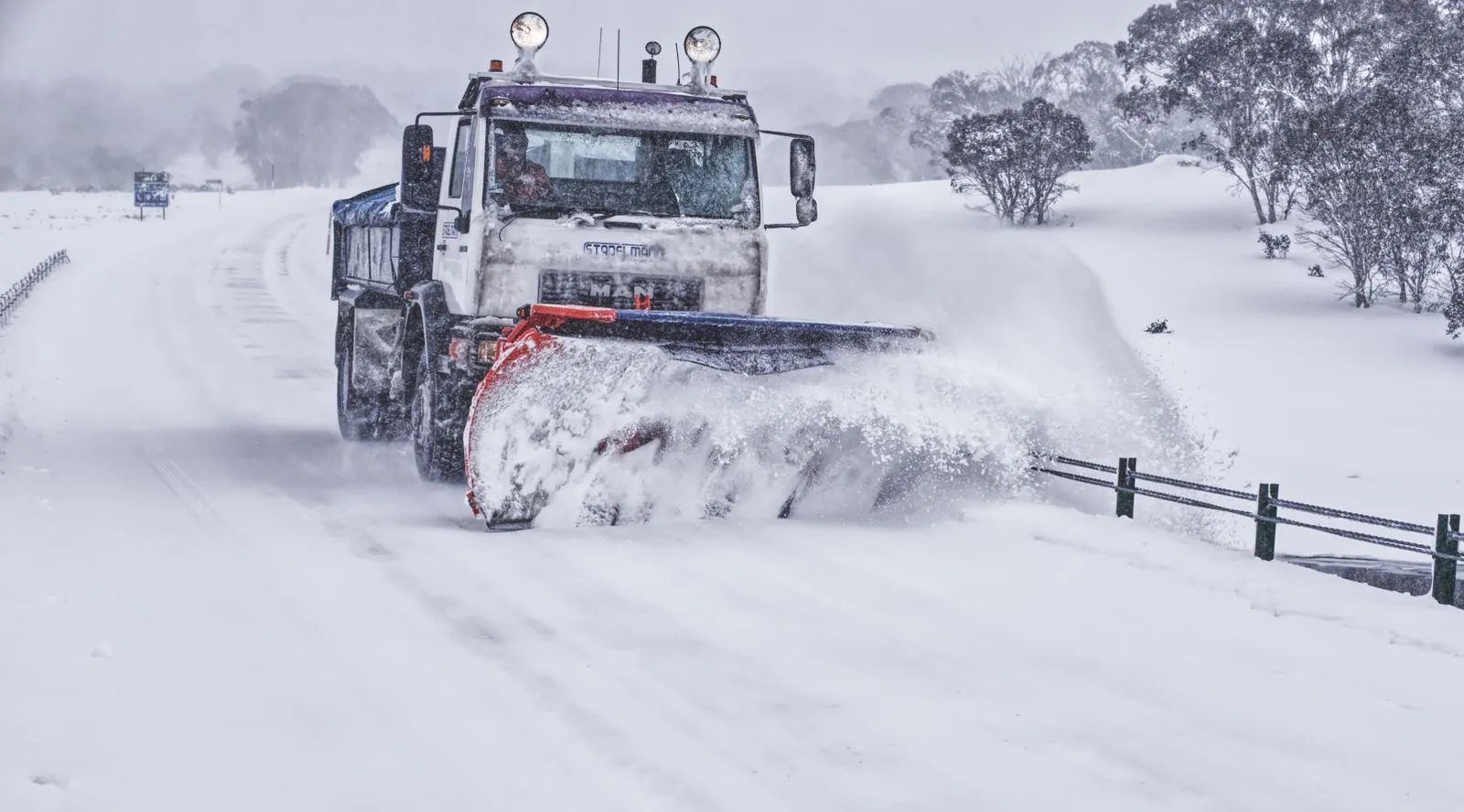 Snow plow truck clearing a driveway in Buffalo, NY